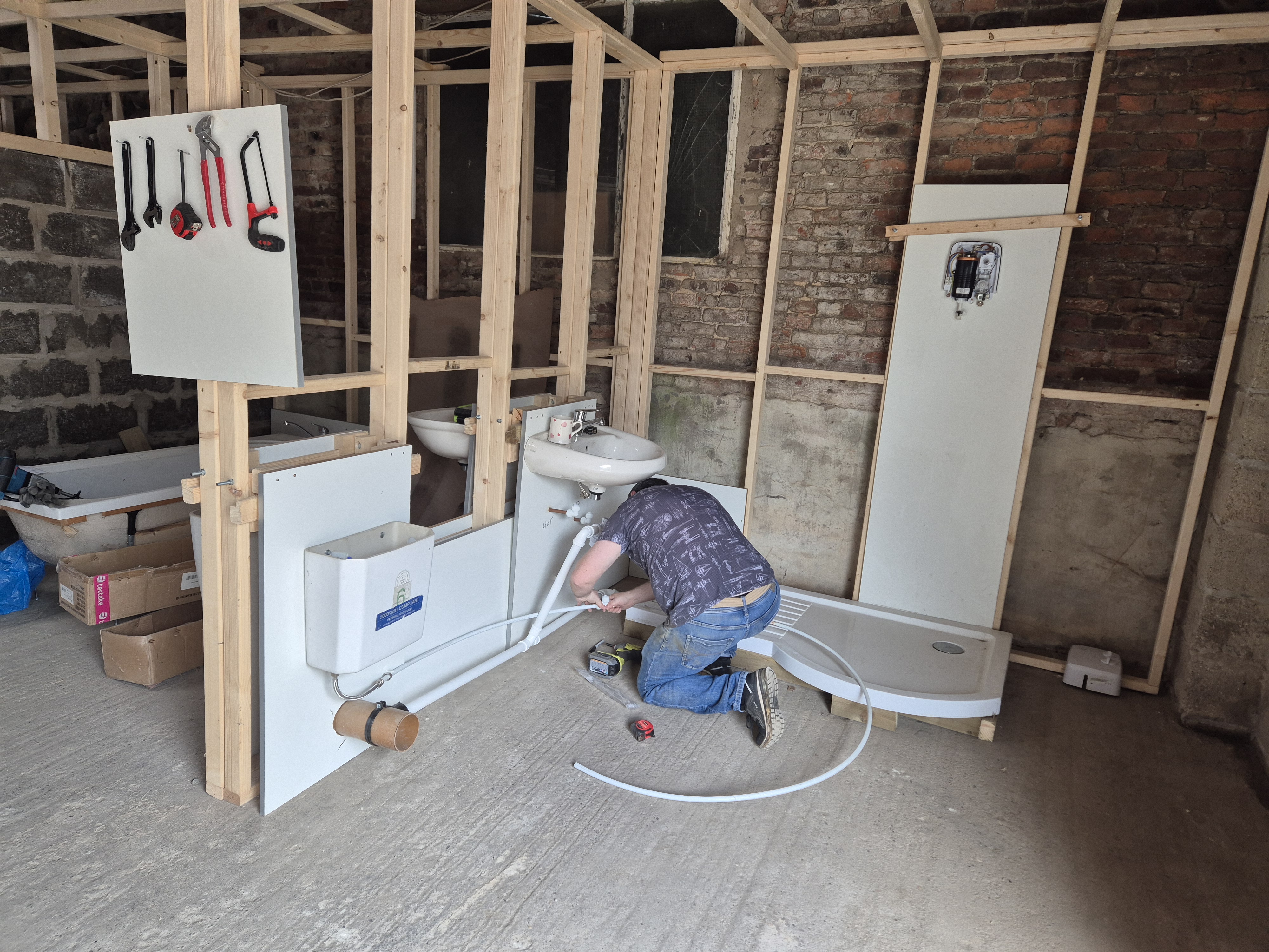 Practical Plumbing course with learners working on a full bathroom training bay
